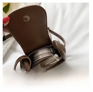 Macro shot of dark brown mini leather crossbody bag showing inner storage for cosmetics