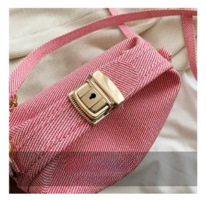 Close-up of pink woven handbag with a decorative gold rectangular metal clasp and textured fabric