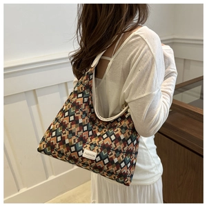 Close-up of geometric jacquard shoulder bag with colorful pattern and fashion label