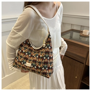 Detail of colorful geometric jacquard shoulder bag with FASHION leather tag and slim strap