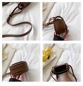 Detail view of a vintage brown leather crossbody bag for kids with adjustable strap