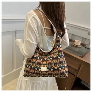 Detail of bohemian knit hobo bag featuring geometric patterns and wooden bead charm