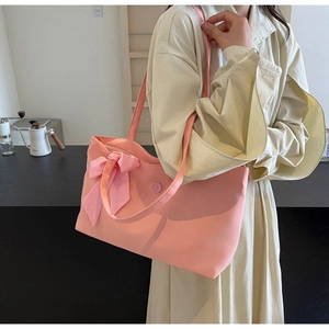 Pink canvas tote bag with silk scarf bow and decorative button shown in hand