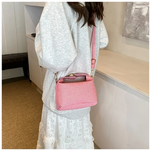 Detail of pink and white striped fabric bucket bag with a detachable shoulder strap