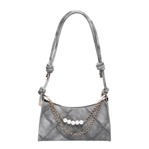 Sac croissant en denim gris avec perles et chaîne dorée sur fond blanc impeccable