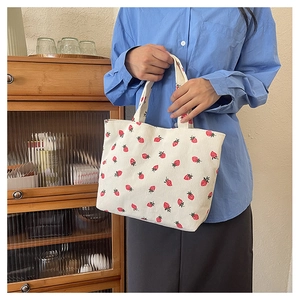 Détail du sac cabas en velours côtelé blanc avec imprimé fraise rouge et vert et texture