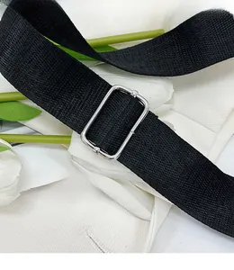 Close-up of adjustable black nylon shoulder strap with silver metal buckle for shell bag