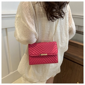 Detail of rose pink chevron quilted crossbody bag with gold chain and metal clasp