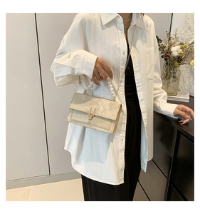 Détail du sac bandoulière tissé crème avec poignée en perles et chaîne dorée