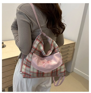 Close-up of pink checkered backpack featuring bow embroidery and adjustable straps