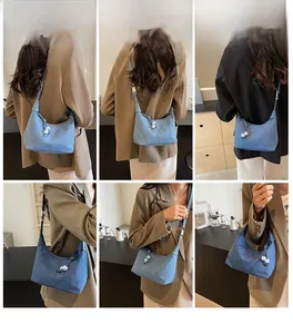 Sac cylindre en jean bleu porté par un mannequin de différentes façons dans un café