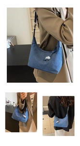 Détails du sac hobo en jean matelassé bleu avec pendentif en perles et bandoulière