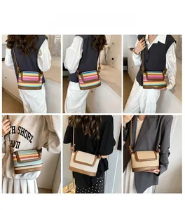 Detailed close-up of rainbow woven shoulder bag with brown leather strap and bottom