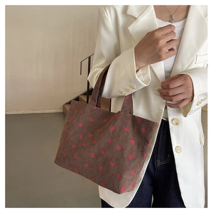 Sac fourre-tout en velours côtelé marron à motifs fraises porté avec un blazer blanc
