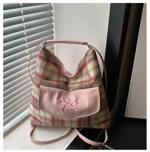 Detailed view of pink plaid fabric bag with bow embroidery and thin shoulder strap