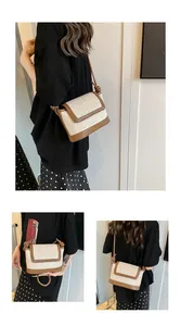 Detail of hand-woven straw crossbody bag with brown leather trim and knotted strap