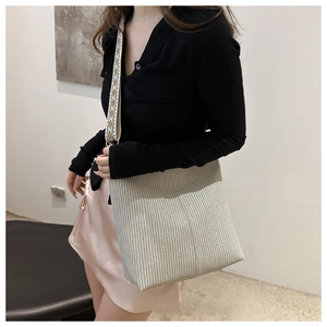 Détail du sac cabas beige tissé avec une large bandoulière à motif jacquard géométrique
