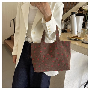 Vue détaillée du sac cabas en velours côtelé marron avec broderie de fraises rouges