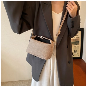 Detailed texture of beige woven fabric crossbody bag with adjustable gold hardware