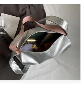 Spacious interior of silver patent leather tote bag with pink strap showing daily essentials