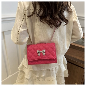 Détail du sac à bandoulière matelassé fuchsia avec nœud argenté et chaîne en métal