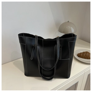 Gros plan sur le cabas noir avec des surpiqûres blanches contrastées et une texture souple
