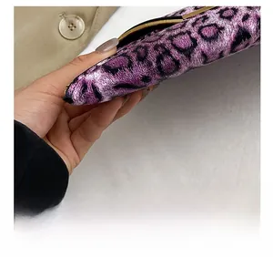 Macro shot of purple leopard print clutch featuring precise stitching and gold metal accents