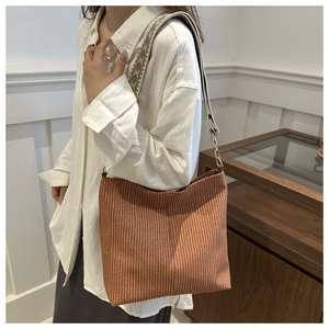 Détail d'un sac cabas tissé avec une large bandoulière aux motifs ethniques