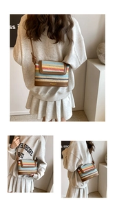 Detail of colorful striped woven crossbody bag with brown leather base and knot strap