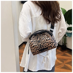 Detail of leopard print crossbody bag featuring adjustable strap and casual canvas texture