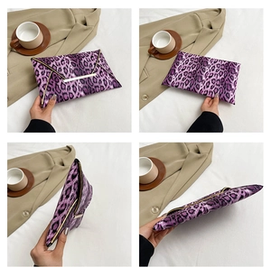 Detail view of purple leopard print envelope clutch with golden metal clasp and slim profile