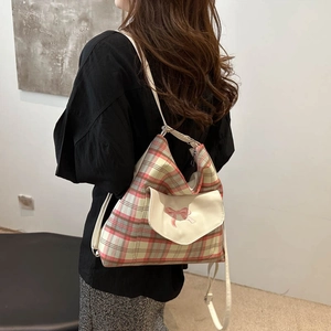 Fashionable checkered tote bag with pink bow detail and adjustable white shoulder strap