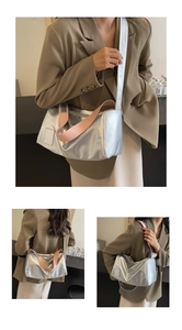 Detailed close-up of metallic silver tote bag with decorative stitching and pink strap