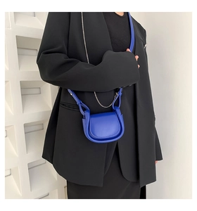 Close-up of a royal blue mini U-shaped crossbody bag with a sleek silver chain strap