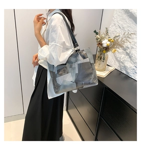 Detail of a large color-block tote bag in gray, blue, and beige with durable black straps