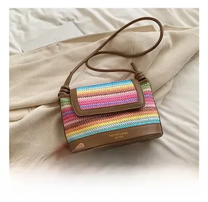 Detailed view of rainbow woven pattern and brown leather bottom with golden logo