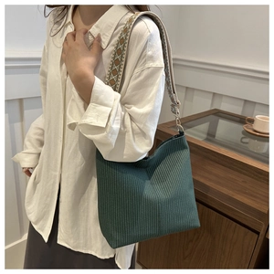 Détail du sac cabas côtelé vert foncé avec une large bandoulière géométrique bohème