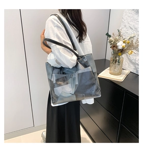 Close-up of canvas tote bag with abstract grey pattern and black leather shoulder straps