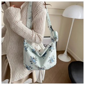 Detailed texture of floral corduroy crossbody bag with a matching small round coin purse