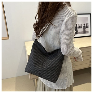Détail du sac cabas tissé noir avec une bandoulière à motifs géométriques noir et blanc