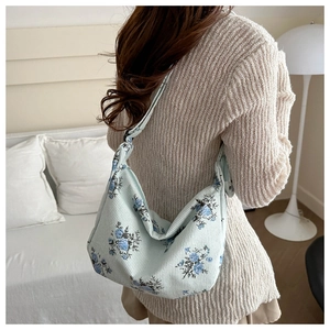 Light blue floral corduroy shoulder bag shown on model for size and style perspective