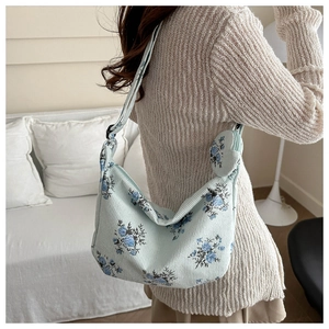 Floral hobo bag with mini pouch on a model in a cozy, bright indoor setting