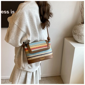 Close-up of woven color stripe crossbody bag with leather trim and fashion text details