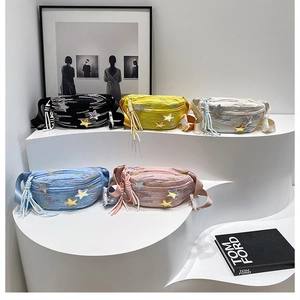 Detailed view of colorful crossbody bags with star embroidery and tassel charms on display