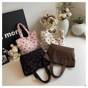 Gros plan de sacs cabas en velours côtelé à imprimé fraise en quatre couleurs variés