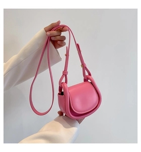 Detail of pink mini crossbody bag in synthetic leather with golden hardware and U-frame