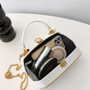 Εσωτερική όψη λευκής τσάντας clutch που δείχνει χώρο για τηλέφωνο και είδη μακιγιάζ