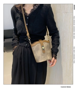 Detail view of contrast stitching and gold twist lock on the retro bucket shoulder bag