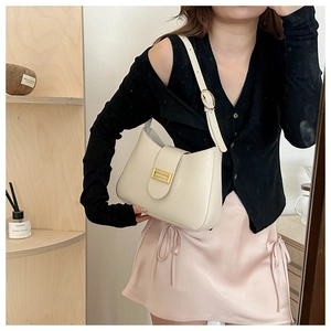 Detail of cream white leather shoulder bag with elegant gold metal buckle closure