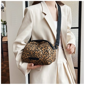 Leopard print crossbody shell bag with adjustable black strap worn on beige blazer